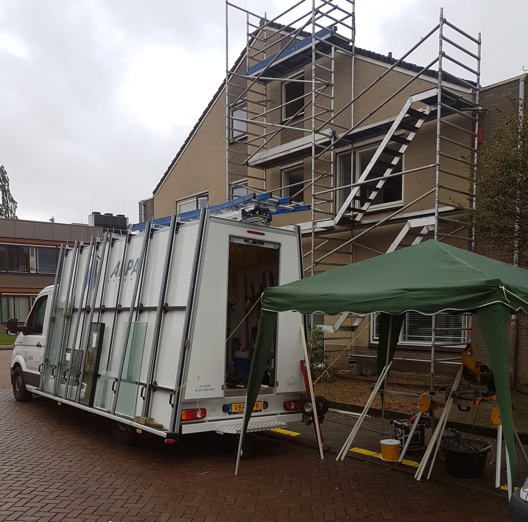 De glasbus van Alpa Totaal op een bouwplaats